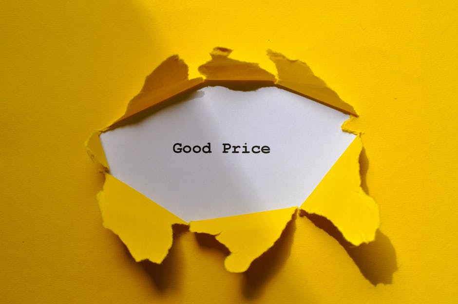 Photograph of a torn yellow paper sheet with jagged edges revealing a white note inside that reads 'Good Price' in black typewriter-style font. The torn paper is attached to a yellow background, sugge